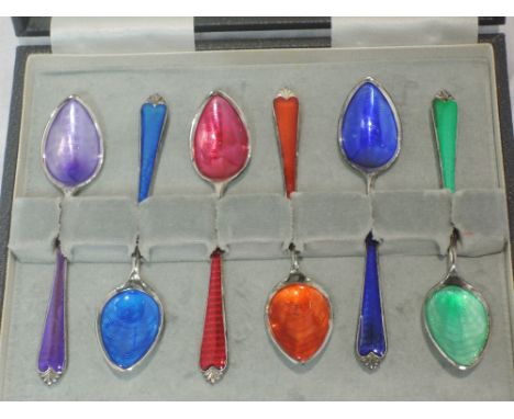 A cased set of six white metal coffee spoons having enamel guilloche decoration in bright colours, retailed by Harvey Nichols