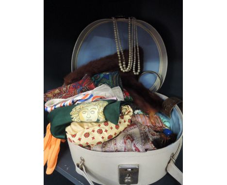 A vanity case containing a selection of vintage scarves and shawls, also included is some jewellery, broaches, dress clips, b