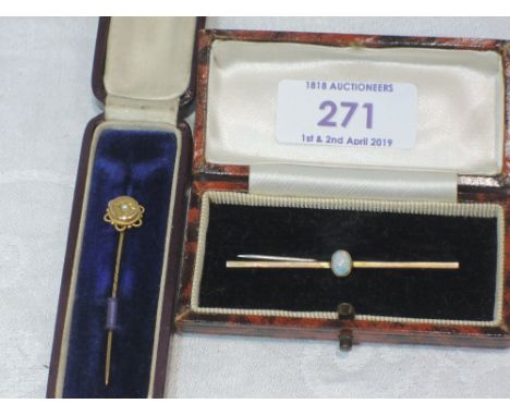 A cased yellow metal bar brooch with central opal stamped 9ct and a yellow metal stick pin stamped 9ct having central seed pe