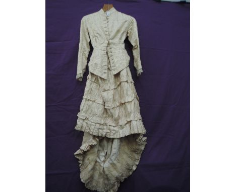 A cream Victorian dress, feels to be silk based having tiered skirt and lace detailing to cuffs, button down front and boned 