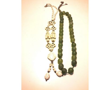 A jade necklace and a stone necklace.