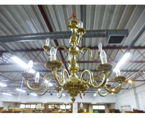 A LARGE HEAVY TWELVE BRANCH TWO TIER BRASS CHANDELIER, and seven brass door knobs (8)