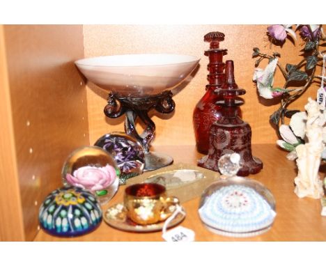 A GROUP OF GLASSWARES, to include Milliflori paperweights, Swarovski Bear (missing ear), two ruby coloured etched decanters e