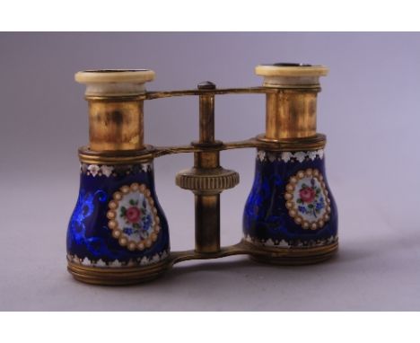 A PAIR OF GILT BRASS OPERA GLASSES, having cobalt blue enamel decoration with floral cartouche and leaf and gilt highlights (