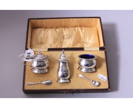 A CASED SILVER THREE PIECE CRUET, of barrel form with blue glass liners, Birmingham 1928-9, approximately 3.5ozt, together wi