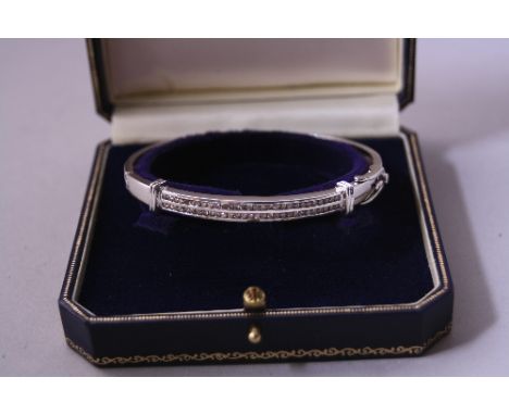 A DIAMOND BANGLE, with two rows of channel set brilliant-cut diamonds, estimated diamond weight 0.60ct, hinge with heart shap