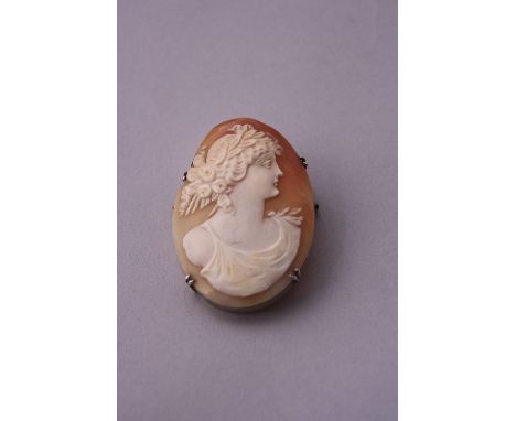 A CAMEO BROOCH, depicting carving of classical female figure in profile to a white metal surround, dimensions 5cm x 3.5cm
