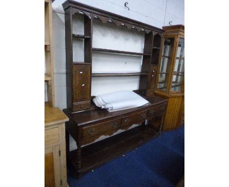 A 19TH CENTURY OAK DRESSER, the plate rack with small cupboards and drawers above three drawers to base on turned front suppo