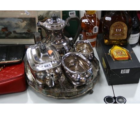 A SILVER PLATED FOUR PIECE TEA SERVICE, together with gallery tray on claw and ball feet