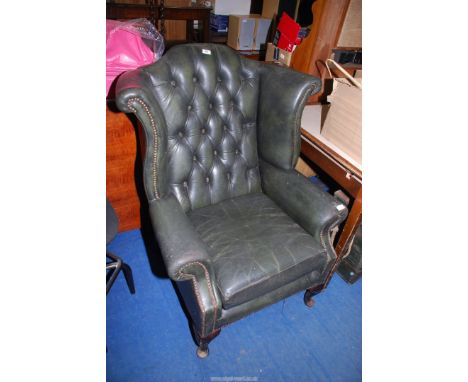 A green leather button back chair.