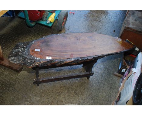 A coffee table with a top made out of a solid wooden tree trunk.