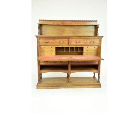 A late Victorian golden oak secretaire sideboardThe raised back with a dentil frieze above a single shelf raised on two brack