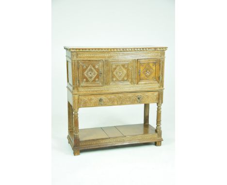 A 17th Century style oak court cupboard, early 20th CenturyWith a rectangular moulded top above a dentil frieze and a central