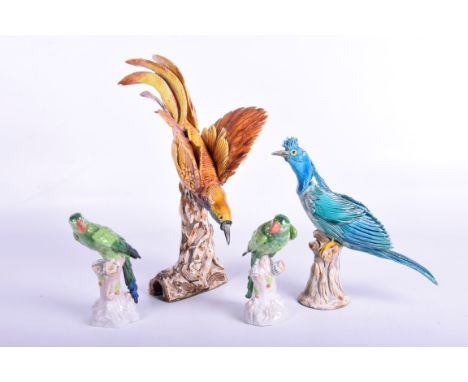 Four assorted continental ceramic bird figures to include
A Bird of Paradise on a naturalistic trunk, a pair of green Cockati