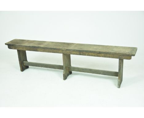 A rustic oak bench Raised on three bracket supports with a plain cross stretcher, 173x48x26cm.