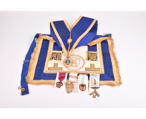 A Masonic sash and apron, With a Cheshire motif badge and an oval silver gilt fob attached also gilt metal, enamel badges and