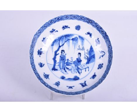 A Chinese porcelain blue and white figural dish, Kangxi period (1662 - 1722)Of circular form, with scalloped rim, the central