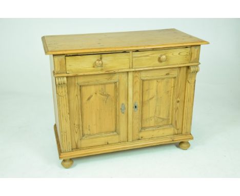 A continental pine side cabinetWith a rectangular moulded top above two short drawers and two panel cupboard doors raised on 