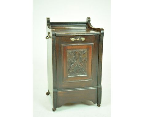 A Victorian walnut coal purdonium The galleried top above a fall front centred with a carved foliate panel flanked by channel