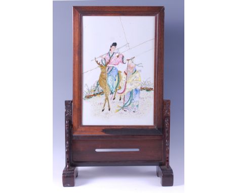 A Chinese Republic period porcelain table screen, enamel decorated with travellers, the whole in Chinese "rosewood" frame and