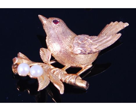 A modern 9ct gold brooch, modelled as a robin upon a branch, having ruby set eye, the branch further set with two small seed 
