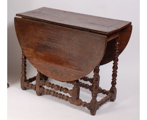 A circa 1700 joined oak gateleg table, the oval fall leaves on bobbin turned and square cut end supports and gatelegs, w.93cm