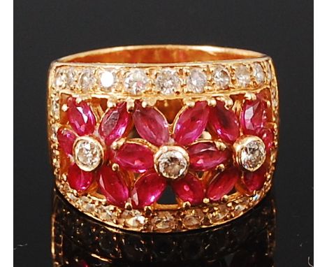 An 18ct gold, ruby and diamond set dress ring, arranged as three flower heads, each centre set with a small brilliant cut dia