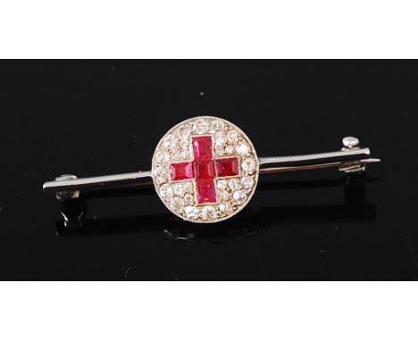 A platinum, ruby and diamond set knife edge brooch, arranged as a centre disc with five baguette cut rubies in a surround of 