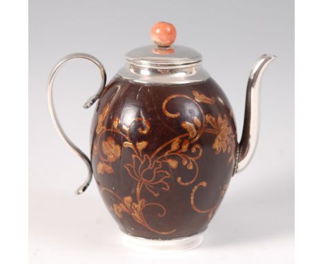 An 18th century lacquered and polished coconut shell teapot, with white metal mounts and handle, the lacquer as scrolling flo