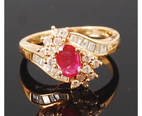 A contemporary 18ct gold, ruby and diamond ring, the oval cut ruby flanked to either side by nine small brilliants, the shoul