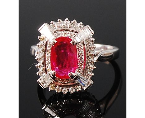 A contemporary 14ct white gold, ruby and diamond dress ring, arranged as a four claw set oval cut ruby weighing approx 1.64ct