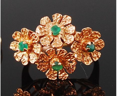 A yellow metal dress ring, the head comprising four textured floral forms, each set with a single green chrysoprase, indistin