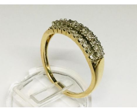 A 9ct gold and diamond ring, claw set with a row of 11x 'Princess Cut'  diamonds and flanked with two further rows of 10 'RBC
