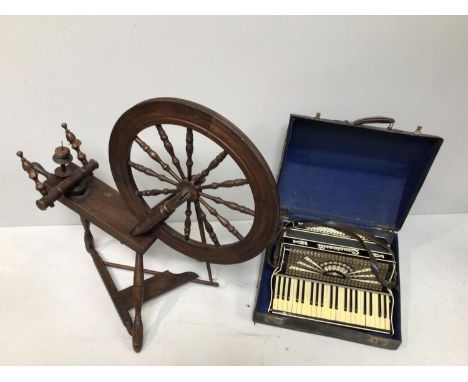 A late 19th / early 20th century fruitwood spinning wheel, approx. 95cm high, together with a Crucianelli accordion in origin