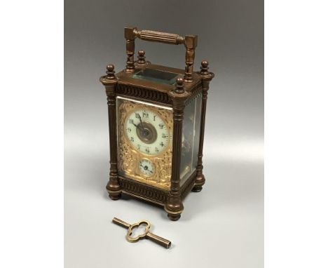 A brass carriage clock by Mappin and Webb, the exposed platform escapement above a gilt, arabesque pierced dial with Arabic n