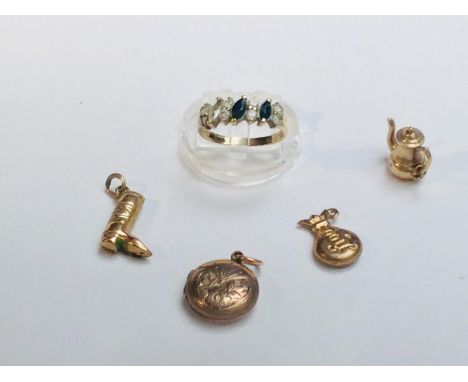 Three 9ct gold novelty charms and a back &amp; front round locket, together with a 9ct yellow gold ring (blue stone missing) 