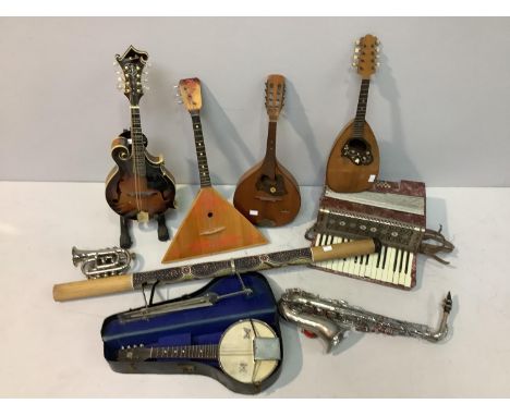 A collection of assorted musical instruments comprising a silver-plated pocket cornet by Bessons &amp; Co. London, a saxophon