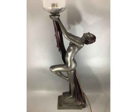 A large art deco style painted composite lamp, styled as a nude female holding aloft the lamp, on rectangular stepped base (l