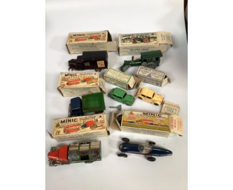 A collection of seven assorted boxed clockwork, tinplate Tri-Ang Minic scale model vehicles comprising a Vauxhall Tourer, a D