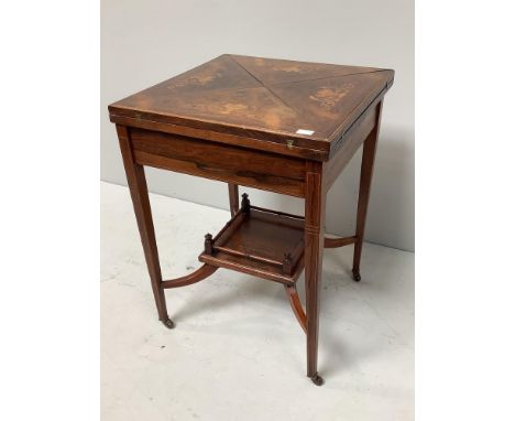 An Edwardian inlaid rosewood envelope card table, the top decorated with urns and scrolled flowers, opening to reveal a gilt-