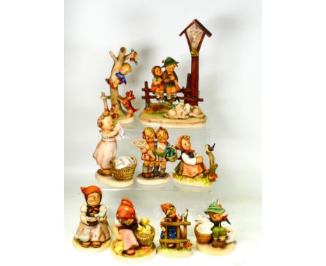 A collection of Goebel Hummel figures including Wayside Devotion, Boy with Bunnies, Girl with Laundry Basket, Girl with Chick
