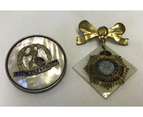 2 military sweetheart badges with mother of pearl detail. Circular silver rimmed badge from the Norfolk Regiment together wit