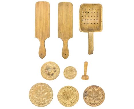 Six treen butter stamps. Carved with flowers and foliage, together with a treen strainer or skimming ladle and a pair of butt