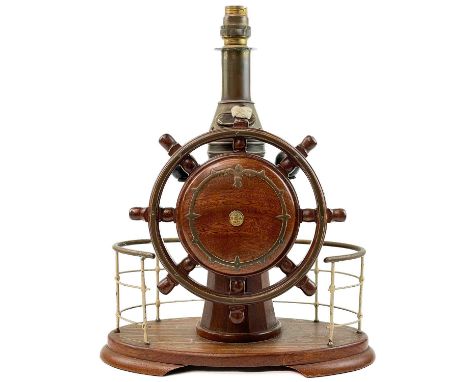 A teak nautical table lamp. Mid 20th century fashioned as a ship's wheel and compass, height 36cm.