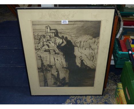 A framed and mounted Lithograph depicting a Monastery and buildings on top of a rocky cliff with a river running below, signe