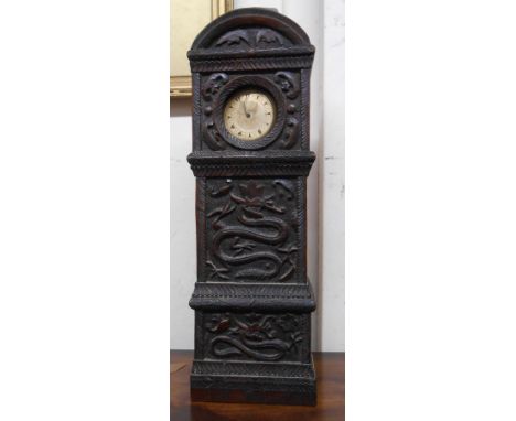 A 32cm high antique carved oak miniature longcase clock pattern pocket watch stand with all over ornate writhing dragon decor