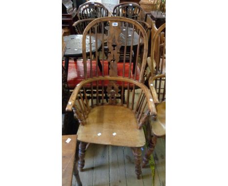 A antique yew and elm Windsor hoop stick back elbow chair with moulded solid elm seat, set on ring turned supports and crinol