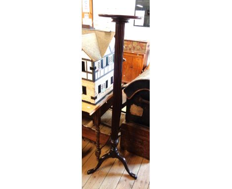 A tall mahogany torchere stand with reeded and turned pillar, set tripod base with pad feet