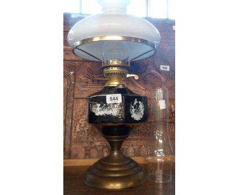 A vintage printed ceramic and brass table oil lamp with spare chimney and milk glass shade