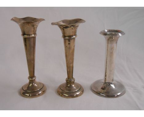 Two damaged silver trumpet vases and a single candlestick with creased base